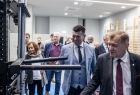 Wicemarszałek Łukasz Smółka ogląda sprzęt sportowy. Obok stoją inni ludzie.
