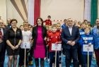 Marta Malec-Lech z zarządu województwa stoi z uczestnikami wydarzenia w hali sportowej.