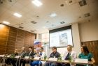 Wicemarszałek Łukasz Smółka siedzi przy stole w sali konferencyjnej. Obok siedzą lekarze.