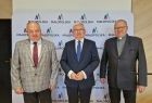 Mężczyzna w szarym garniturze, wicemarszałek Józef Gawron i kapłan w czarnym garniturze. 