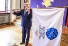Marszałek Witold Kozłowski prezentuje flagę Igrzysk Europejskich. 