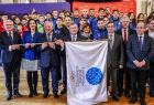 Marszałek Witold Kozłowski i oficjele trzymający flagę IE.