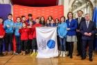 Dzieci trzymające flagę Igrzysk. Obok członek zarządu Marta Malec-Lech, radny Piotr Dziurdzia i marszałek Witold Kozłowski. 