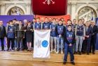 Młodzież w klubowych koszulkach trzymająca flagę IE.
