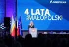 Widok na kobietę stojąca na scenie, kobieta jest w trakcie wystąpienia. 