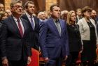 Posłowie na Sejm RP – Anna Pieczarka i Wiesław Krajewski oraz wiceprzewodniczący sejmiku województwa Wojciech Skruch stoją na baczność w pierwszym rzędzie wśród publiczności.