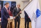 Witold Kozłowski trzyma rozwiniętą flagę