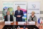 Marszałek Witold Kozłowski zwraca się do zebranych. Obok w sali sesyjnej urzędu gminy siedzą Iwona Gibas z zarządu województwa oraz burmistrz Brzeszcz Radosław Szot