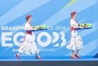 Panie w strojach ludowych wnoszące medale przed ceremonią dekoracji sportowców