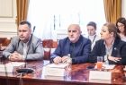 Grupa osób siedzi przy stole obrad