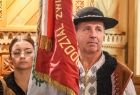 góral w stroju regionalnym trzymający sztandar