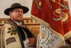 góral w stroju regionalnym trzymający sztandar