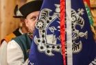 góral w stroju regionalnym trzymający sztandar
