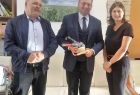Wicemarszałek Łukasz Smółka stoi z ludźmi trzymając w rękach przyrząd strażacki.