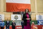 Marta Malec-Lech z zarządu województwa stoi przy mikrofonie. Za nim widoczna flaga biało-czerwona.