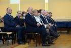 Goście wydarzenia siedzą, przyglądając się programowi artystycznemu w wykonaniu dzieci