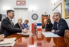 Wicemarszałek Łukasz Smółka siedzi przy stole i rozmawia z delegacją z Francji.