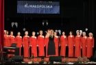 Chór kobiecy w czerwonych sukniach na scenie