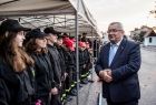 Minister Andrzej Adamczyk stoi przed młodymi strażakami.