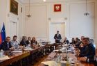 Wicemarszałek Łukasz Smółka stoi przy stole i przemawia do uczestników wydarzenia.