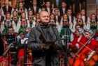 Opat cystersów stoi na środku kościoła i przemawia. Za nim stoi zespół "Mazowsze".
