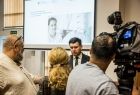 Wicemarszałek Łukasz Smółka stoi przed grupą dziennikarzy.