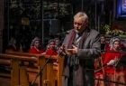 Prezydent Krakowa Jacek Majchrowski stoi na środku kościoła i przemawia. Za nim stoi zespół "Mazowsze".
