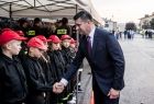 Wicemarszałek Łukasz Smółka podaje rękę młodemu strażakowi.