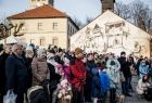 Ludzie stoją podczas jarmarku na rynku. W tle widoczne zabytkowe kamienice.