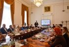 Uczestnicy wydarzenia siedzą przy stole konferencyjnym.