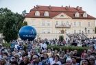 Ludzie na widowni podczas koncertu. Z tyłu widoczny balon z napisem Małopolska i zabytkowy budynek.