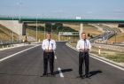 Prezydent RP Andrzej Duda i minister Andrzej Adamczyk stoją przy mikrofonach ustawionych na drodze.