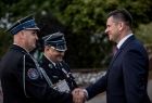 Wicemarszałek Łukasz Smółka podaje rękę strażakowi.