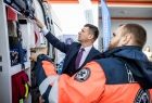 Wicemarszałek Łukasz Smółka ogląda sprzęt karetki, obok stoi ratownik.
