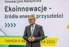 Prowadzący wydarzenie na tle bannery "Ekoinnowacje"