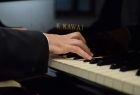Na zdjęciu ręce pianisty na fortepianie.