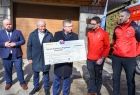 marszałek Witold Kozłowski prezentuje symboliczny czek z sumą pieniędzy przekazaną dla ratowników GOPR