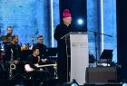Arcybiskup Marek Jędraszewski przemawia z mównicy na scenie.