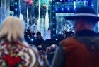 Na pierwszym planie górale. W tle Edyta Górniak na scenie.