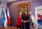 Iwona Gibas z zarządu województwa oraz prezes Marcin Nowak podają sobie ręce. Obok stoi wiceprezydent Oświęcimia Krzysztof Kania