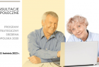 Para seniorów - kobieta i mężczyzna siedzących przy stole przy otwartym laptopie, patrzących przed siebie i uśmiechających się wzajemnie.