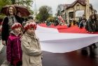 Parada patriotyczna. Dzieci niosące ulicami Oświęcimia wielką biało-czerwoną flagę