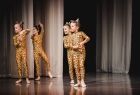 Dziewczynki w strojach kotów tańczą na scenie