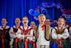 Dzieci w strojach regionalnych śpiewają na scenie