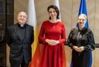 Kapłan w czarnym garniturze, członek zarządu Marta Malec-Lech i kobieta w czarnej sukience.