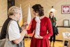 Kobieta w czarno-białej koszuli wręcza prezent członek zarządu Marcie Malec-Lech.