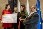 Członek zarządu Marta Malec-Lech wręcza promesę na 10 000 złotych dwóm kobietom i mężczyźnie.