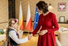 Dziewczynka w stroju regionalnym podaje rękę członek zarządu Marcie Malec-Lech.