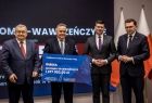 Samorządowcy, wojewoda i minister prezentujący czek dla gminy Igołomia-Wawrzeńczyce