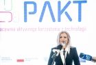 Poseł na Sejm RP Anna Pieczarka mówi do mikrofonu.W tle widoczny napis: PAKT.